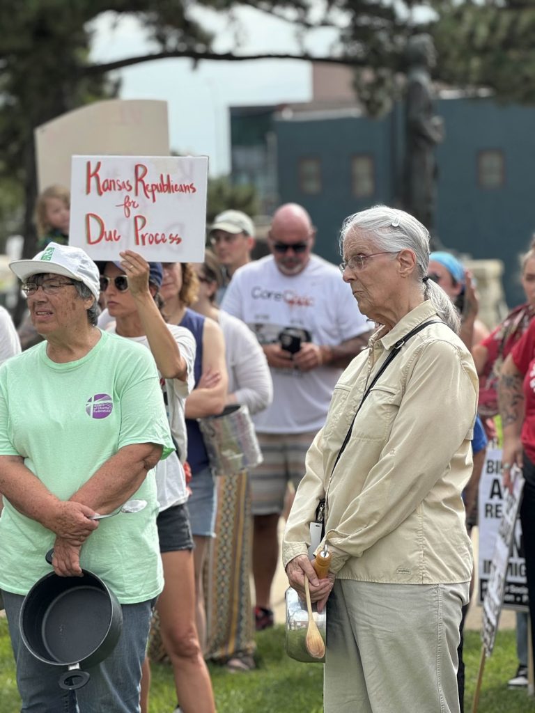 Sisters Pat Johannsen and Susan Chase listen to a speaker at the "Pots and Pans March."